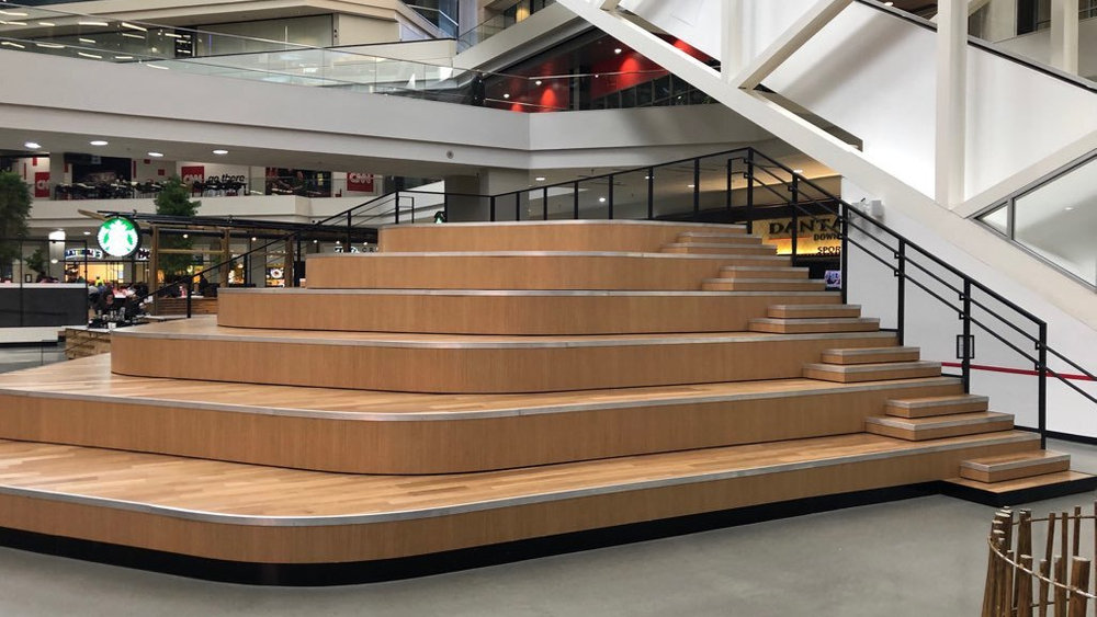 The atrium of CNN Center, featuring acrylic-infused engineered hardwood flooring on a staircase, with restaurants and a Starbucks in the background.