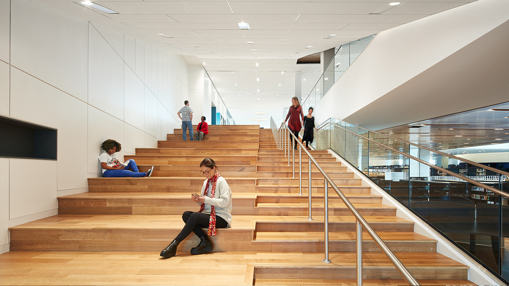 Hardwood staircase at a public library in Durham, North Carolina, where visitors enjoy reading and exploring.